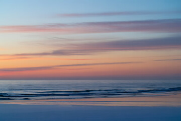Obraz premium Serene Sunset Over Calm Icy Ocean Waters 