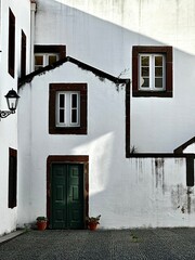 Entrance of an old white building with sunlight reflection