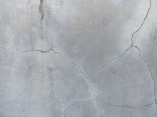 Cracked Grey Concrete Texture. A close-up of a light grey concrete surface with distinct, intricate...