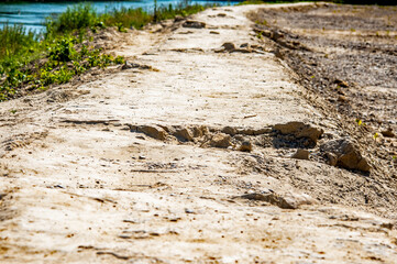 Sandiger Weg mit Riss und Spuren in der Landschaft