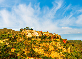 scenic morning or evening mountain town in morning or evening sun rays with yellow buildings and golden green nature background of highland