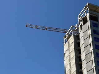 Tower Crane on tall building construction. crane on apartment buildings site, Multi Storey Residential Buildings construction, with blue sky background