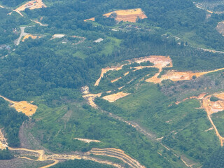 Aerial view of a logging yard in the sumatra indonesia rainforest, located in a clearing surrounded by dense forest.
