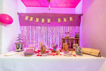 Candy bar pink wedding decorated standing of festive table with deserts, strawberry tartlet and cupcakes