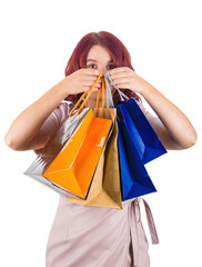 Young redhead woman hide face behind colorful shopping bags in her hands. Sale campaign concept isolated on transparent background