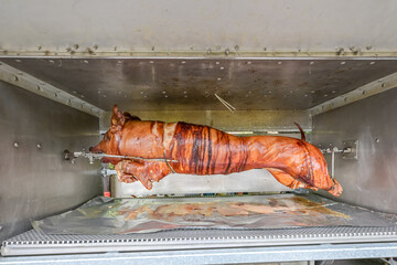 Barbecue with young pig grill Whole roasted piglet body turning on grill. Large barbecue in the process of cooking meat