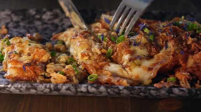 A person cuts a portion of potato pancakes.