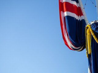 Flag of the United Kingdom with the colors of the nation red, white, blue. Abstact view of the flag with blue sky background