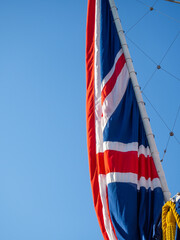 Flag of the United Kingdom with the colors of the nation red, white, blue. Abstact view of the flag with blue sky background