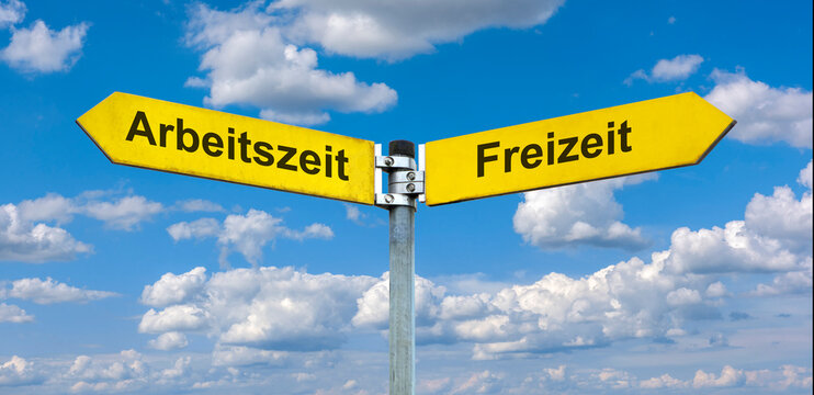 Zwei Wegweiser zeigen in unterschiedliche Richtungen und sind beschriftet mit dem Aufdruck Arbeitszeit vs. Freizeit - FOTOMONTAGE