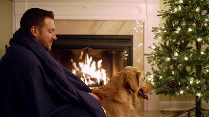 Caucasian man cuddling a golden retriever dog by a cozy fireplace near a decorated christmas tree during a peaceful winter evening. concept of warmth, companionship, holiday season. - Powered by Adobe