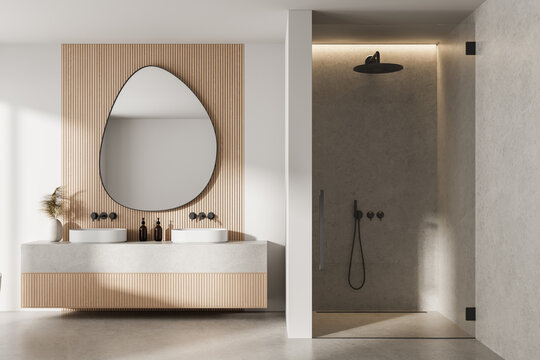 Modern minimalist bathroom interior with wood panel wall, asymmetrical mirror, dual sinks, and walk-in stone shower under warm ambient lighting. 3D Rendering