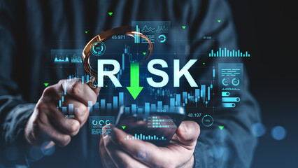 Businessman analyzing financial risk with magnifying glass and digital graphs on screen for investment and protection management concept.