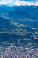 Beautiful aerial view of Innsbruck city with Bergisel ski jump and Wipptal valley from Hafelekarspitze peak in spring on a sunny day, Innsbruck, Austria