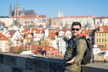 Hombre presentando las vistas de Praga desde el Puente de Carlos. Hombre sorprendido por la belleza de Praga