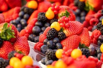 Delicioso combo de frutos rojos en mercado callejero: fresas, arándanos, moras y otras frutas deliciosas