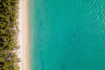 Aerial top view of beautiful turquoise water and white sand tropical "Mon Choisy" public beach, Mauritius island, Indian Ocean