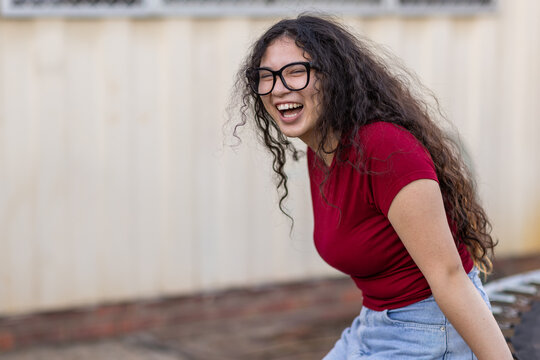 teenage girl wearing glasses laughing with mouth open