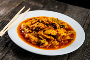 Sichuan fried chicken with vegetables on a dark background. Chinese cuisine. Food concept