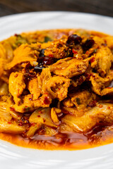 Sichuan fried chicken with vegetables on a dark background. Chinese cuisine. Food concept