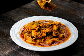Sichuan fried chicken with vegetables on a dark background. Chinese cuisine. Food concept