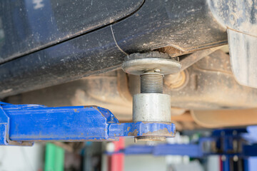 Hydraulic lifting axle machine, using to lift the car for service at automotive garage. Transportation and industrial equipment, close-up with selective focus.