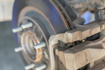 Car wheel disc brake and caliper part that disassembled from inspection. Vehicle equipment part object, close-up with selective focus.