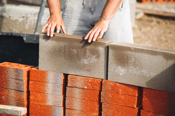 Bricklayer laying bricks on building site