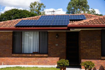 solar panels in full sun on a tiled suburban roof