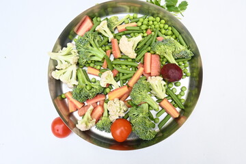 Vibrant medley of fresh vegetables. Features broccoli, cauliflower, tomatoes, Carrot, green beans, and peas. colourful vegetables of spring time, Its good for health. colorful display.