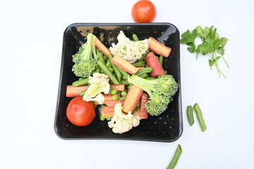 Vibrant medley of fresh vegetables. Features broccoli, cauliflower, tomatoes, Carrot, green beans, and peas. colourful vegetables of spring time, Its good for health. colorful display.