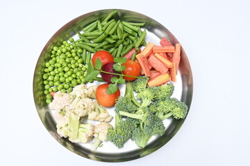 Vibrant medley of fresh vegetables. Features broccoli, cauliflower, tomatoes, Carrot, green beans, and peas. colourful vegetables of spring time, Its good for health. colorful display.