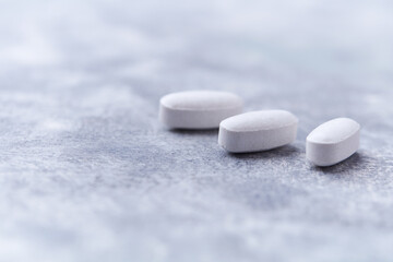 Amino acids tablets on wooden background. Soft focus. Close up	