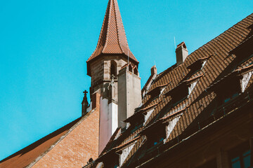 Old architectural building in Nuremberg city against blue bright sky. Cityscape
