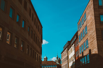 Old architectural building in Nuremberg city against blue bright sky. Cityscape