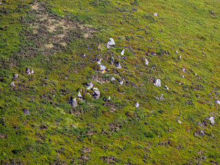 Green grassy cape Cabo da Roca, Sintra, Portugal with green grass and rocks on the slopes on a warm...