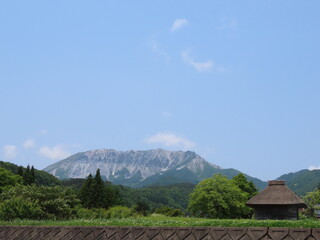 日本の古い建築物と大きな山が見える景色（大山）