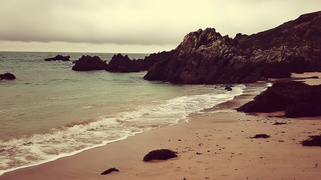 Serene coastal scene calm waves lap a sandy beach, framed by dark rocks and a brooding sky