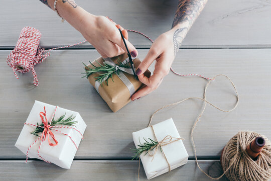 Overhead view of wrapping Christmas gifts and cutting ribbon