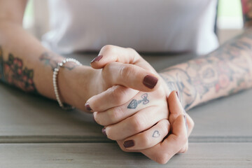 Close up of tattoos on clasped hands of a young woman