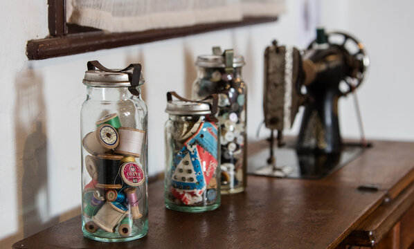 Vintage jars of sewing items with an old singer sewing machine