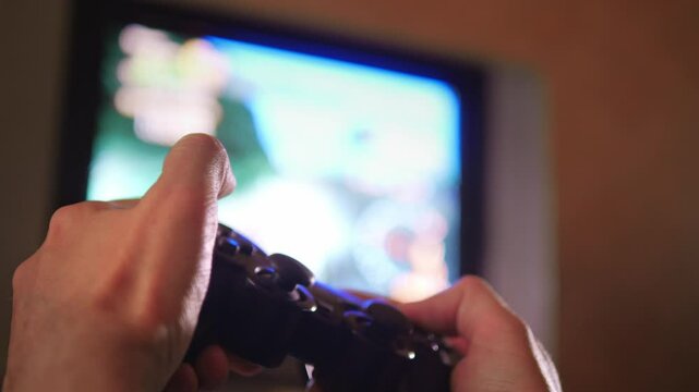An engaged and immersive mood is captured as hands expertly manipulate a game controller, with the blurred action of a video game visible on an older television screen in the background