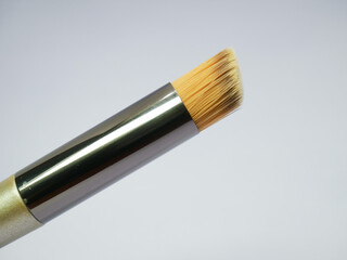 Tapered makeup brush close-up with worn bristles