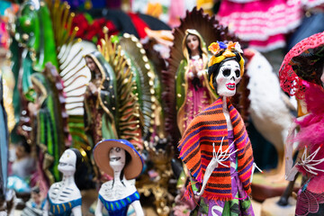 Colorful Mexican figurines featuring La Catrina and the Virgin of Guadalupe, capturing the vibrant spirit of Day of the Dead and folk religious traditions
