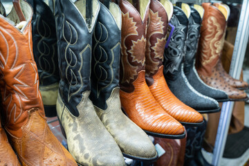 Handcrafted Mexican cowboy boots in various exotic leathers and colors displayed in a traditional Guadalajara market stall