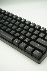 A mechanical keyboard with a 61% layout in black from the top with a white background.