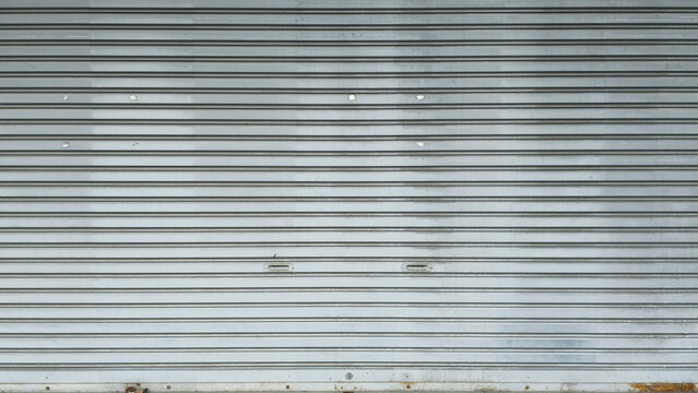 Rolling door. Steel shutter door of warehouse. The shutters are gray metal. Steel rolling shutter background. Silver metal rolling shutter background. Background images and texture images.