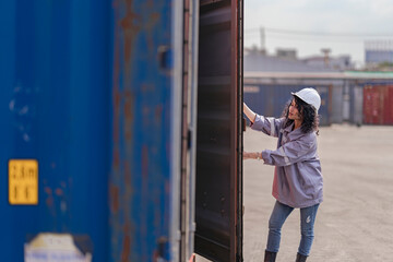 asian woman logistics workers walking to check container. operations at a busy shipping container...