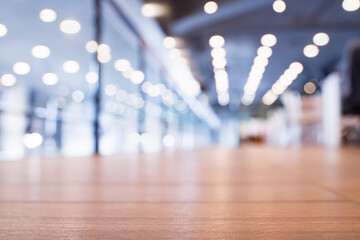 Modern office space features wooden flooring, bright lights, and a blurred background of...