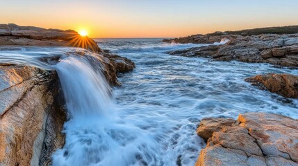 Coastal sunrise, water cascading over rocks into the ocean